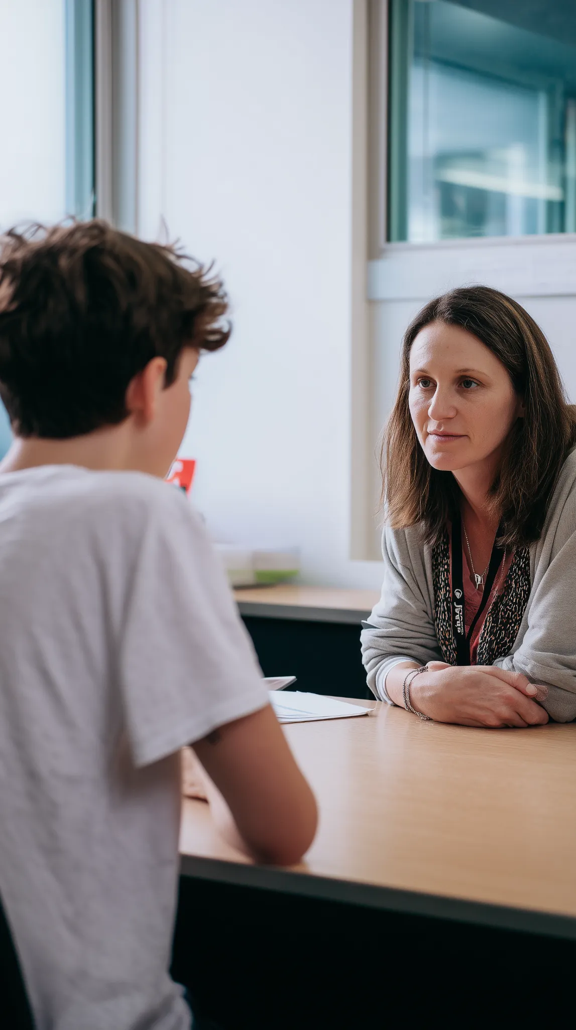 youth-counsellor-support-session Counsellor listening attentively to a young person during a one-to-one support session in a bright office setting.
